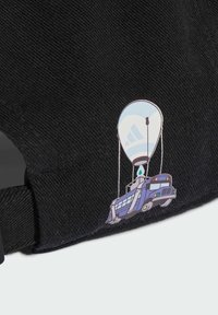 Černá čepice s karikaturou modrého vozidla s balónem nad hlavou, podrobně doplněná logem a příslušenstvím.