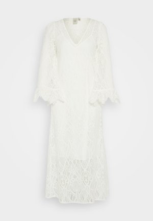 White lace dress with a V-neck, long sleeves, and flared cuffs. Intricate floral and geometric patterns feature throughout the fabric.