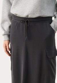 Zwarte jerseyrok met een elastische tailleband en verstelbaar trekkoord. Voorzien van zijzakken en een gladde textuur. Casual ontwerp.