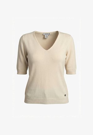 Maglia a maniche corte color crema con scollo a V, polsini e orlo a coste, e piccolo logo metallico a forma di cuore vicino all'orlo inferiore.