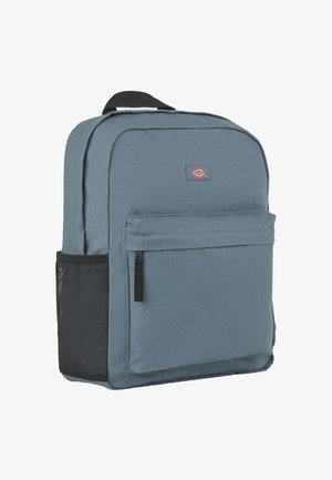 Zaino grigio con design rettangolare imbottito, dotato di una tasca frontale con zip, una tasca laterale in rete e una tracolla nera regolabile.