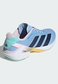 Light blue athletic shoe with mesh upper, navy stripes, pastel accents, and a white midsole. Features rear cushioning and textured surfaces.