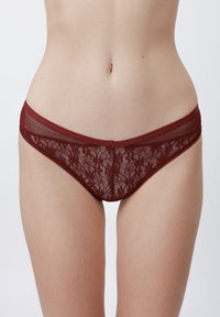 Culotte en dentelle bordeaux avec un motif floral, taille en mesh transparent et bords festonnés. Texture douce avec un design de coupe classique.