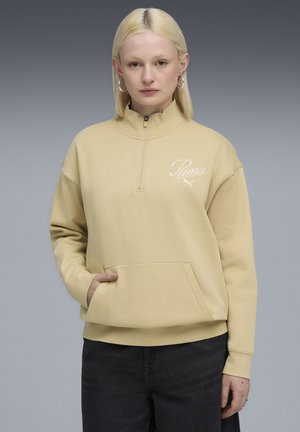 Lys gul zip-up sweatshirt med høj krave, som har en kengurulomme og hvidt logo på brystet. Glat stoftekstur.