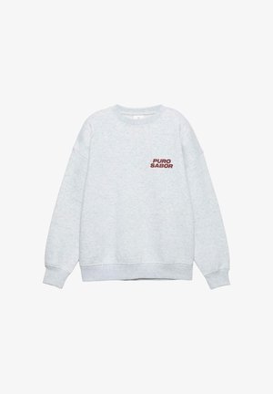 Hanorac gri din material mixt de bumbac. Are manșete și tiv striate, cu inscripția „PURO SABOR” imprimată cu burgund pe pieptul stâng.