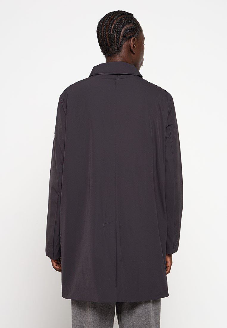 Czarny płaszcz z kołnierzem, długimi rękawami i prostym krojem. Posiada gładką fakturę i pojedynczy wentyl z tyłu.