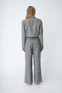 Grijs geblokt pak met een slim fit blazer en wijde broekspijpen, met een zachte textuur en subtiel ruitpatroon, gezien vanaf de achterkant.