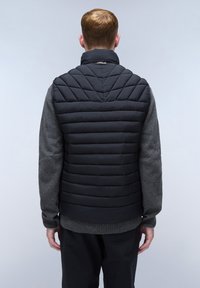 Schwarze Pufferweste mit einem Rautenmuster, hohem Kragen und grauen Strickärmeln. Rippdetails am Saum vervollständigen den Look.