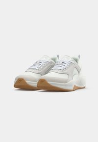 Hvide sneakers med mesh- og ruskindsmaterialer, struktureret gummisål i nødderfarve, rund tå og et strømlinet design med snørebånd.