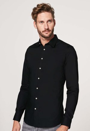 Zwarte langslavige shirt met een knoopsluiting, voorzien van een klassieke kraag en witte knopen, gemaakt van glad, lichtgewicht materiaal.