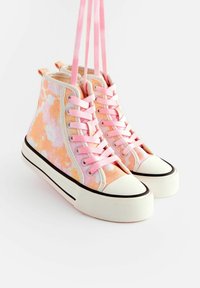 Visoke tenisice od ružičastog i narančastog tie-dye platna, s ružičastim vezicama, bijelim gumennim potplatom i crnim obrubom duž rubova.