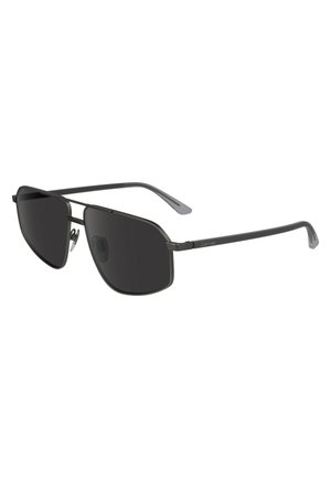 Lunettes de soleil avec verres foncés, monture en métal noir mince, forme angulaire et logo discret sur les branches. Accentuées avec des plaquettes de nez pour le confort.