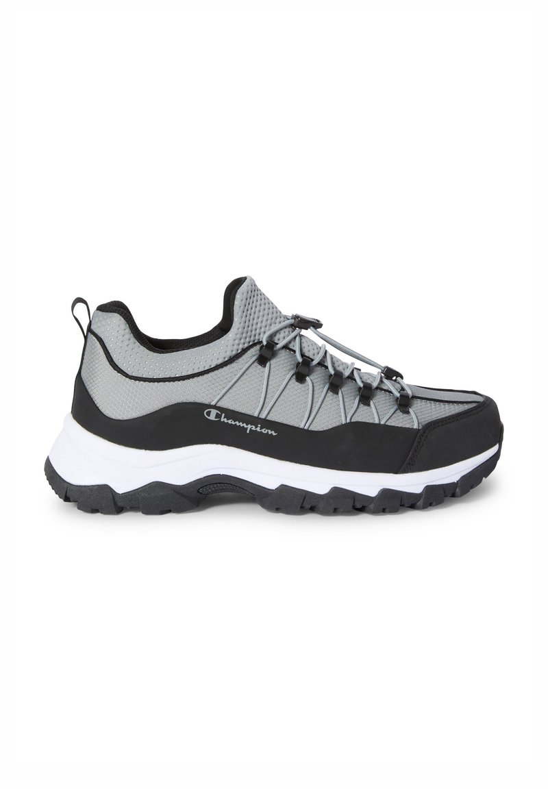 Scarpa da trekking in mesh grigio e gomma nera con suola robusta, caratterizzata da un design con lacci e logo sul lato. Punta arrotondata e colletto imbottito.