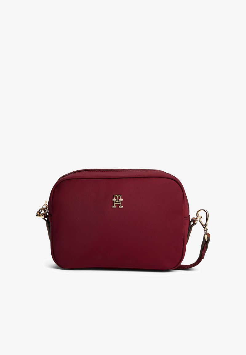Borsa a tracolla bordeaux realizzata in tessuto testurizzato, con logo dorato, chiusura con zip e tracolla regolabile. Forma rettangolare compatta.