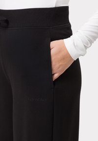 Schwarze, weiche Stoff-Sweatpants mit einem breiten Bund. Mit seitlichen Taschen und einem dezenten, auf das Bein gestickten "LES LUNES"-Logo.