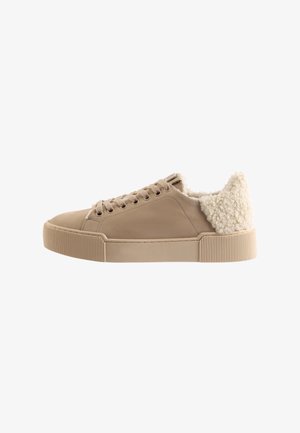 Beige suede sneaker with lace-up front and cream-colored sherpa lining around ankle and heel, flat rubber sole.
