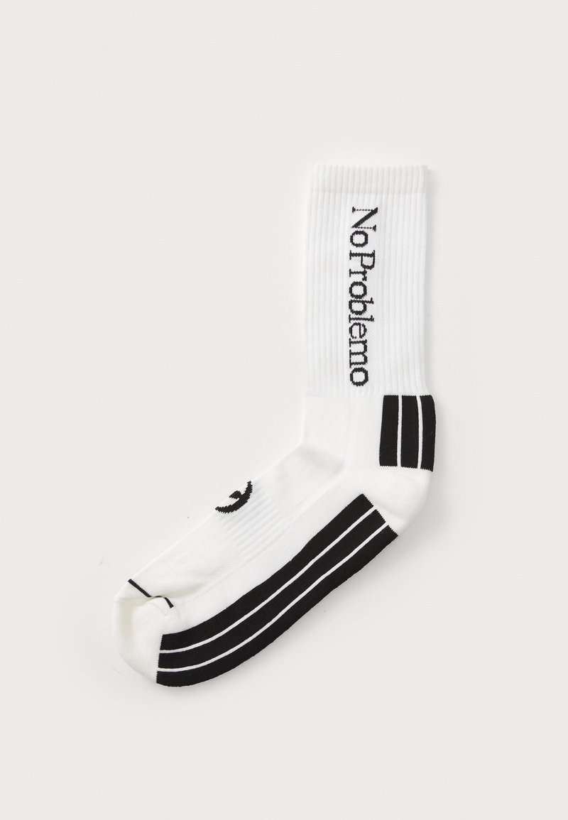 Chaussette de sport blanche avec des accents noirs, présentant le texte « No Problemo » et des rayures horizontales à la cheville. Texture côtelée, design mi-mollet.
