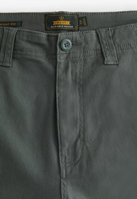 Grau gerade geschnittene Hose aus strapazierfähigem Material mit Knopfverschluss, mit dezenten Nähten und einem Etikett von 'Next Durable Goods'.