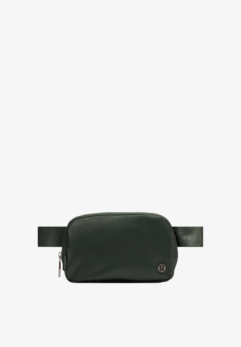 Sötétzöld tasak sima anyagból, cipzárral záródik, és szövetpánttal rendelkezik. Kis logó az oldalon. Téglalap alakú.