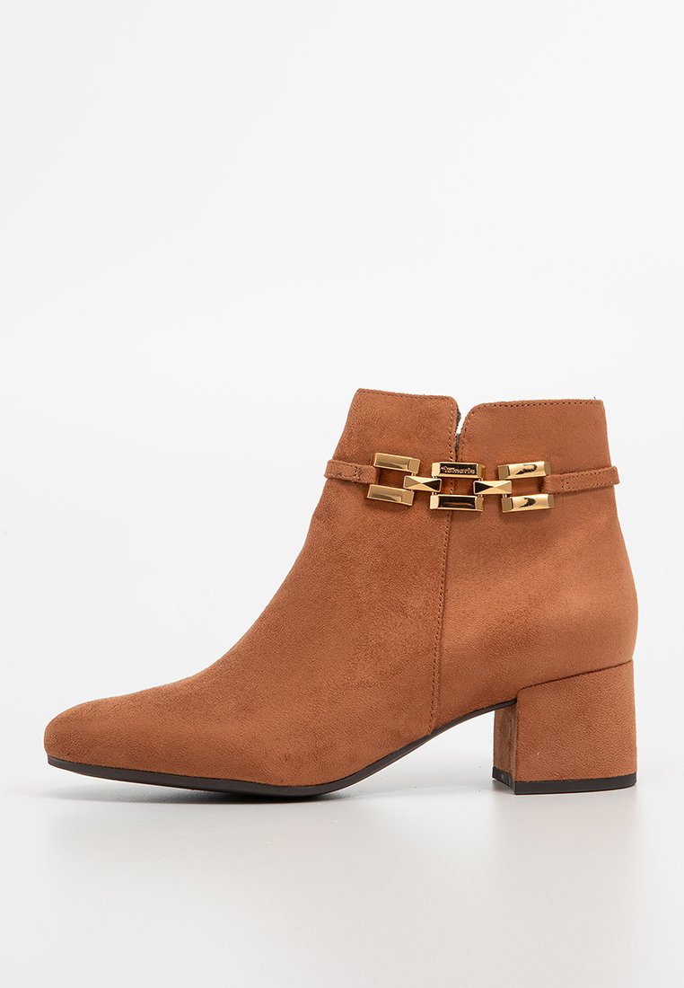 Braune Wildleder-Ankle-Boots mit Blockabsatz und goldener dekorativer Schnalle an der Seite, auf weißem Hintergrund präsentiert.