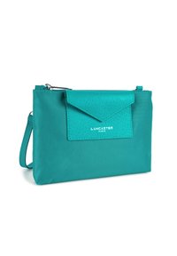 Borsa clutch color teal realizzata in materiale testurizzato con chiusura a patta e cerniera. Presenta un logo discreto sul davanti e un cinturino da polso removibile.