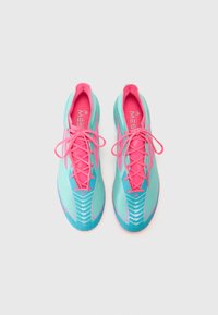 Light blue athletic shoes with pink laces and accents. Features a textured upper, aerodynamic design, and pronounced grip on the sole.