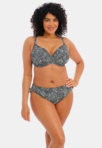 Ensemble de bikini à pois noirs et blancs avec un soutien-gorge sculpté et un bas taille basse assorti. Comprend des bretelles ajustables et une texture de tissu douce.