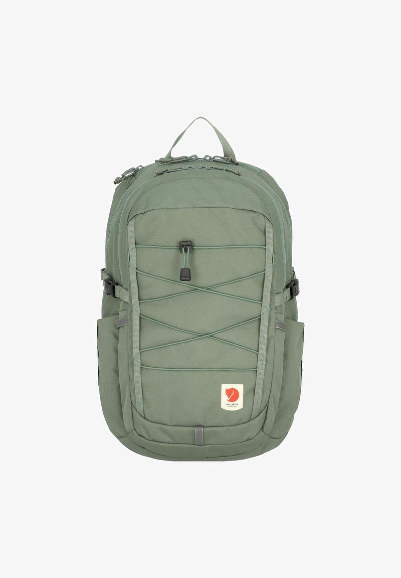 Groene stoffen rugzak met een stevig ontwerp, voorzien van mesh zijvakken, een bungee koord aan de voorkant en een logo patch aan de onderkant.