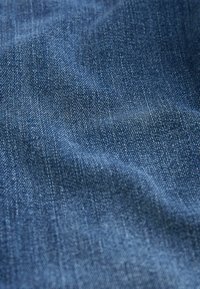 Mörkblå denimtyg med en mjuk textur, med en diagonalt twill-väv och lätt variation i tonerna. Inga synliga mönster eller beslag.