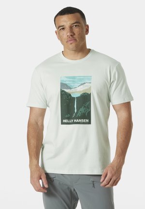 Lichtgroene katoenen T-shirt met een centraal grafisch ontwerp van bergen en een waterval, met de tekst "HELLY HANSEN" onderaan. Korte mouwen.