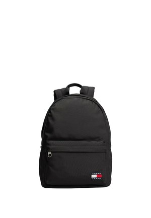 Zaino nero in tessuto, con una tasca frontale con zip e una patch con logo. Parte superiore arrotondata, spallacci regolabili e texture liscia.
