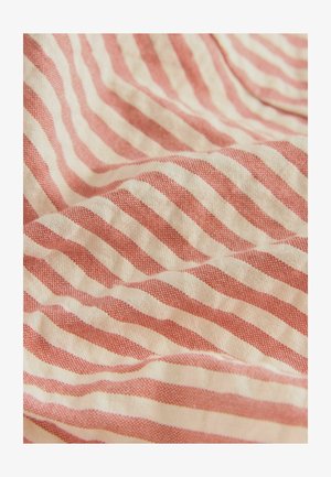 Kratak tkanina u crvenoj i krem boji s prugama ima teksturiranu sredinu s naizmjeničnim horizontalnim linijama. Materijal izgleda mekan i lagan.