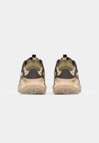 Storage shoes with a dark gray textile upper, beige midsole, and patterned rubber outsole. Features a pull tab and Vibram logo accents.