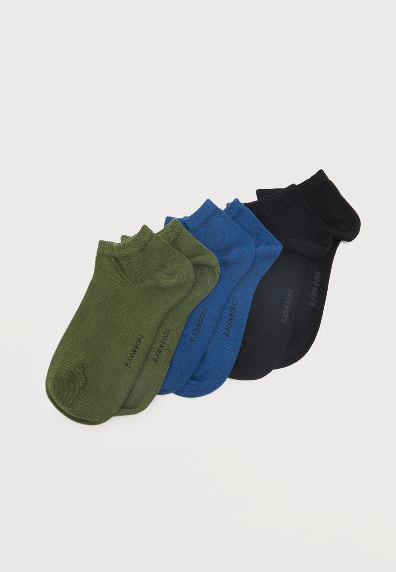 Trois paires de chaussettes basses en vert, bleu et noir, disposées côte à côte sur un fond blanc.