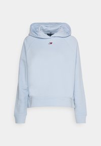 Jasnoniebieska bluza z kapturem z prążkowanym dołem i mankietami. Z przodu ma małe logo w kolorach czerwonym, białym i granatowym. Miękka struktura materiału.