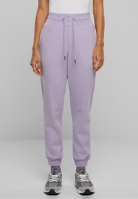 Lilla joggebukser med elastisk midjebånd, snøring og ribbestrikkede mansjetter. Laget av mykt stoff, med side lommer og en avslappet passform.