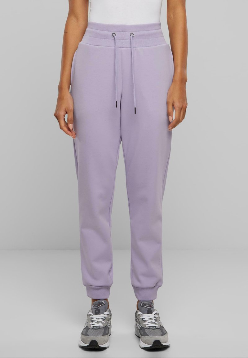 Lilla joggebukser med elastisk midjebånd, snøring og ribbestrikkede mansjetter. Laget av mykt stoff, med side lommer og en avslappet passform.
