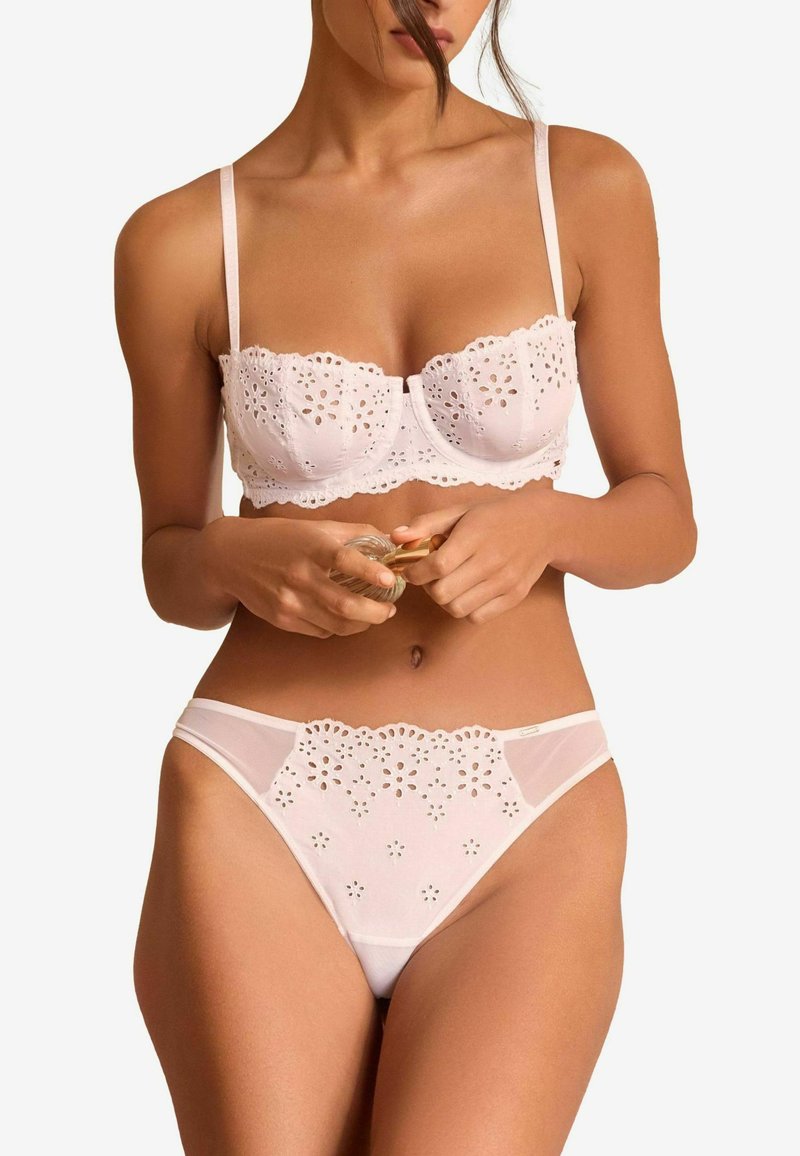 Čipkasti bralet i odgovarajući hipster gaćice u svijetlo ružičastoj boji, s cvjetnim izrezanim uzorcima i valovitim rubovima. Mekana tkanina s prozirnim detaljima.