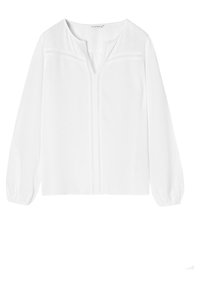 Blusa bianca a maniche lunghe con colletto rotondo, tessuto strutturato e cuciture decorative sul fronte. Vestibilità ampia con polsini arricciati.