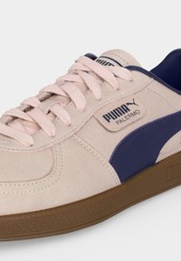 Beige ruskind Puma Palermo sneaker med pink snørebånd, navy blå stribe og hælkant samt brun gummisål.