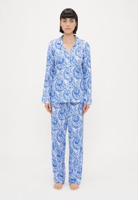 Kék és fehér mintás pizsama szett hosszú ujjú felsővel és egyenes szárú nadrággal, paisley mintázattal és szegélyezett gallérral.