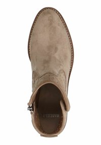 Beige nahkasaappaat nilkkamallilla, joissa on reikäkoristeet ja hopea solki. Pyöreä kärki ja ommellut yksityiskohdat pohjan ympärillä, mikä tuo esiin tekstiilistä koostuvan materiaalin.