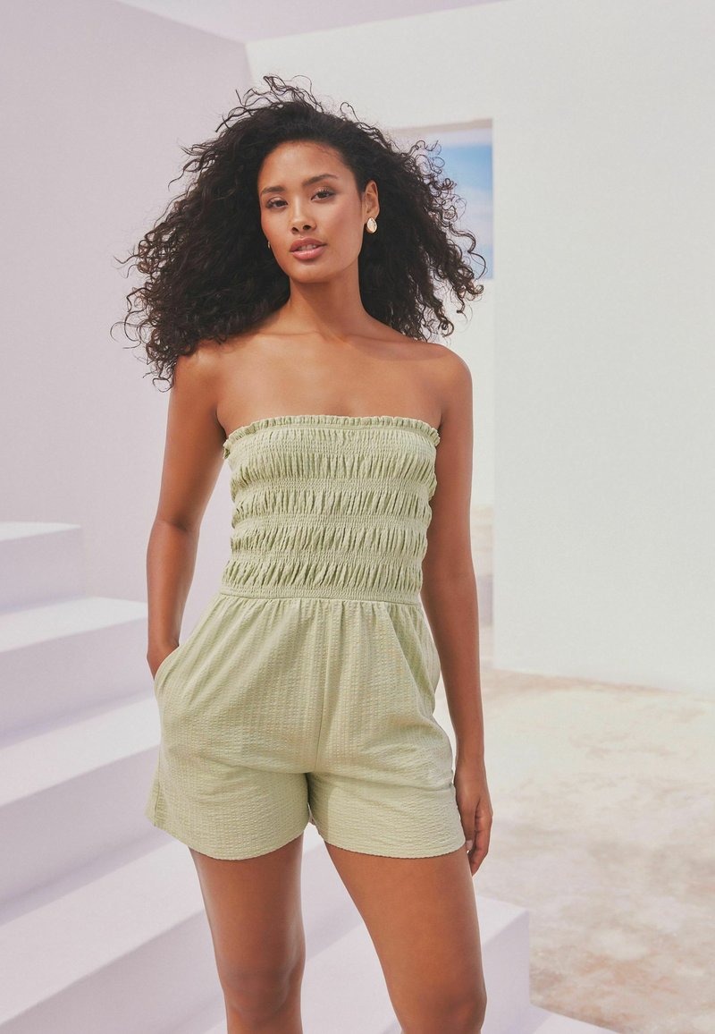 Mono verde sin tirantes con textura fruncida, busto ajustado y pantalones cortos relajados, que presenta bolsillos laterales y una tela ligera y transpirable.