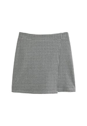 Zwart-wit houndstooth patroon A-lijn minirok met een zijsplit, weergegeven op een witte achtergrond.