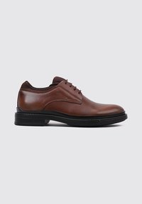 Zapato de vestir de cuero marrón con acabado suave, sistema de cordones y una duradera suela de goma negra. Punta redondeada y cuello acolchado.