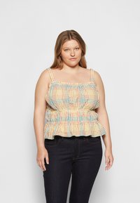 Top peplum xadrez em tons de amarelo, laranja e azul. Apresenta alças ajustáveis, cintura franzida e caimento descontraído com uma bainha larga.