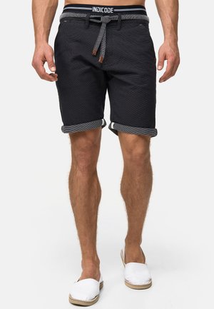 Marineblå shorts med et tekstureret stof, oprollende manchetter og et kontrasterende elastisk livbånd med logo. Designet med snorelukning.