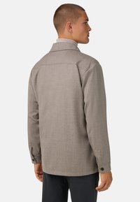 Šedá strukturovaná bunda s límcem a knoflíkovými manžetami, s rovný střih. Na zadní straně jsou jemné švy.