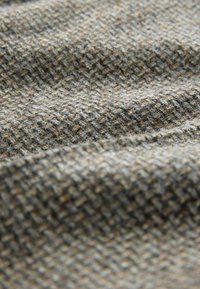 Woven fabric in shades of brown and gray. Features a textured, checkered pattern with a soft, slightly fuzzy surface.