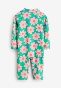 Grön barnens rash guard med långa ärmar och ett blommönster med stora rosa blommor och orangea centrum. Slätt, elastiskt material.